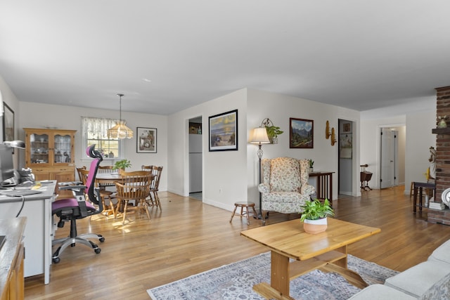 living area featuring light wood-style flooring and baseboards