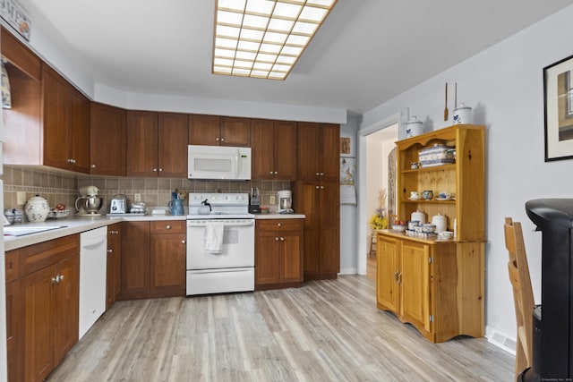 kitchen with light wood finished floors, open shelves, light countertops, decorative backsplash, and white appliances