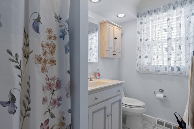 bathroom featuring toilet, vanity, visible vents, and a shower with curtain