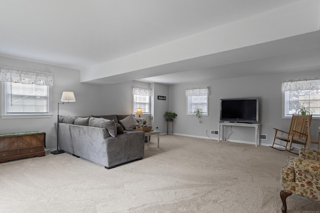 carpeted living room featuring baseboards and a healthy amount of sunlight