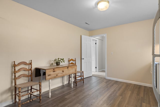 sitting room with wood finished floors, visible vents, and baseboards