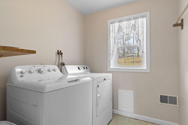 clothes washing area with laundry area, visible vents, baseboards, light floors, and washing machine and dryer