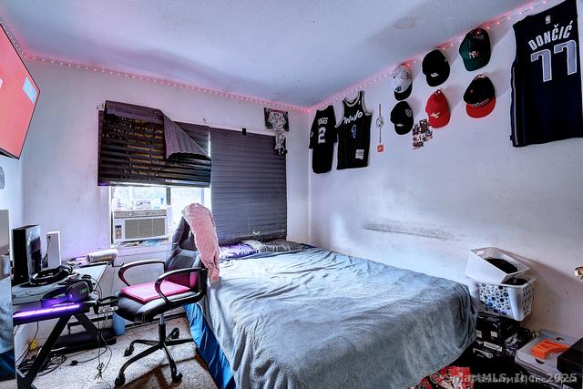 bedroom with light carpet and cooling unit