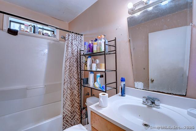full bathroom with toilet, shower / bath combo, and vanity