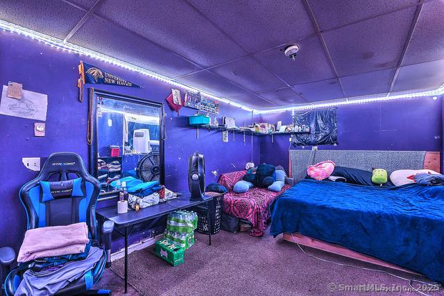 carpeted bedroom featuring a drop ceiling