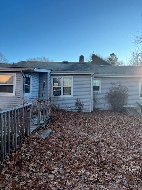 back of property with a chimney