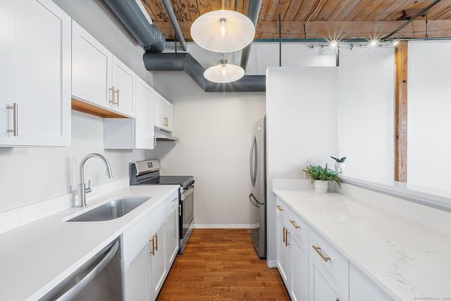 kitchen with stainless steel appliances, white cabinetry, a sink, and light stone counters