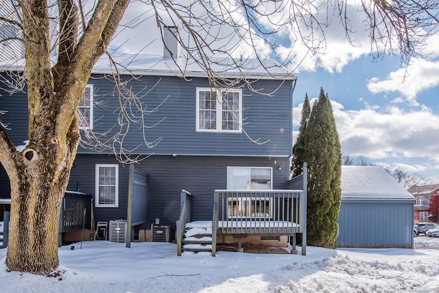 snow covered rear of property with a wooden deck