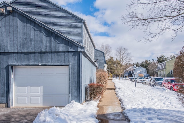 view of snowy exterior with a garage