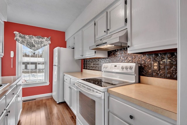 kitchen featuring tasteful backsplash, light countertops, white cabinetry, white appliances, and under cabinet range hood