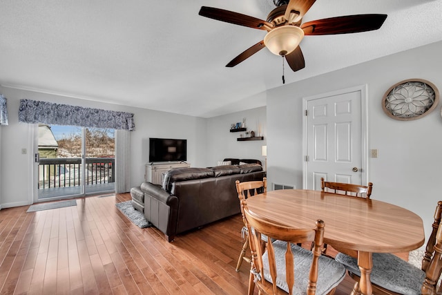 dining room with light wood-style floors, a textured ceiling, and a ceiling fan