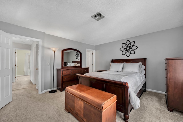 bedroom with attic access, visible vents, baseboards, and light colored carpet