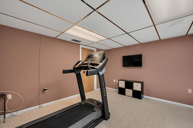 exercise area with visible vents, carpet floors, a paneled ceiling, and baseboards