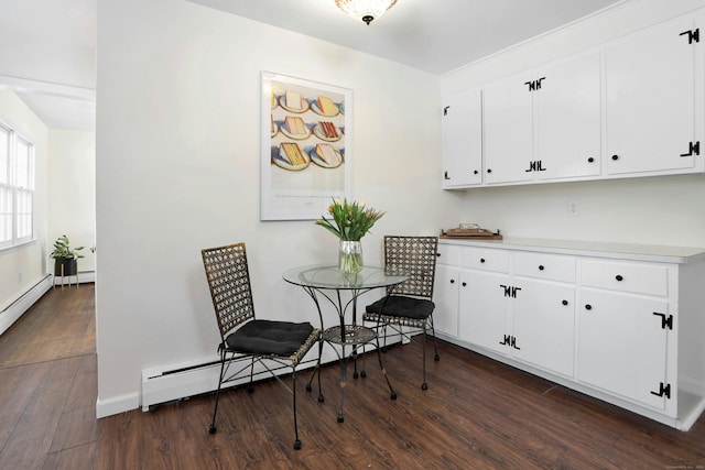 dining area with baseboards, a baseboard heating unit, and dark wood-style flooring