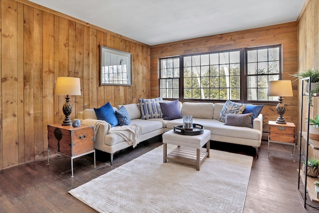 living room featuring wood walls, a baseboard heating unit, and dark wood finished floors