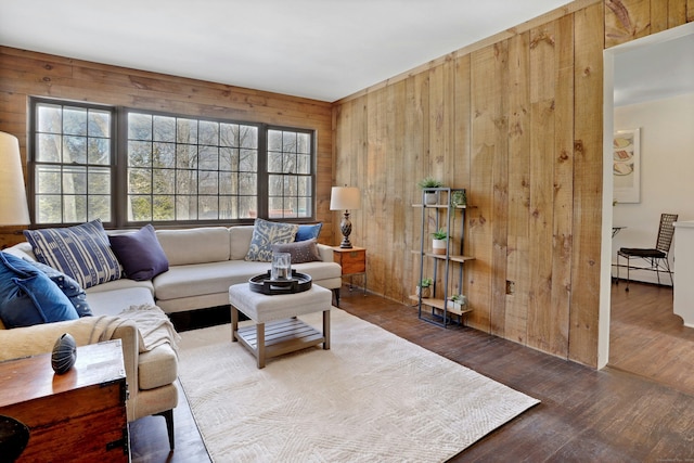 living area featuring a baseboard radiator, wood finished floors, and wooden walls