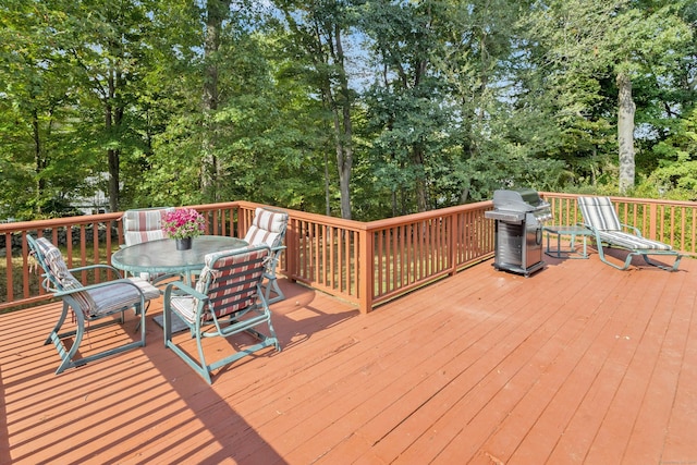 wooden terrace with outdoor dining area and area for grilling