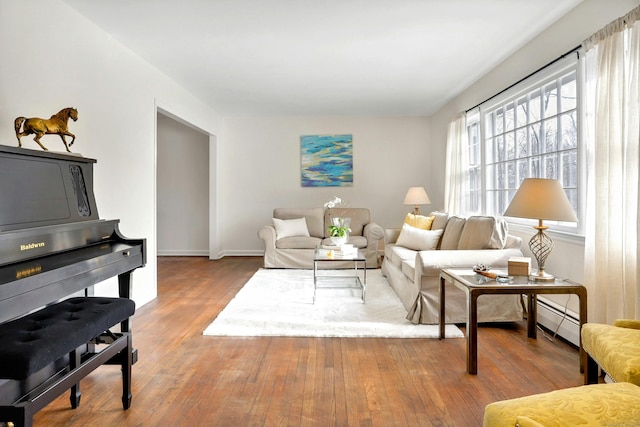 living room with baseboards, baseboard heating, and hardwood / wood-style floors