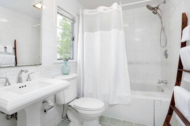 bathroom featuring tiled shower / bath, a sink, and toilet