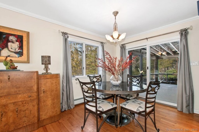 dining space with an inviting chandelier, ornamental molding, and wood finished floors