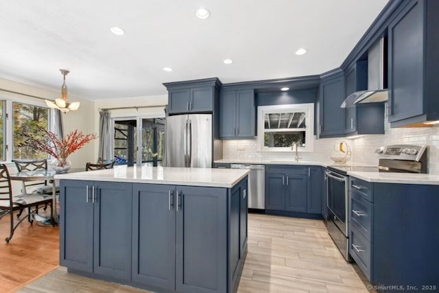 kitchen featuring blue cabinetry, stainless steel appliances, and light countertops