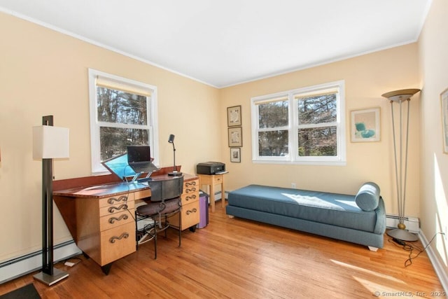 home office with light wood finished floors, a baseboard heating unit, baseboard heating, and crown molding