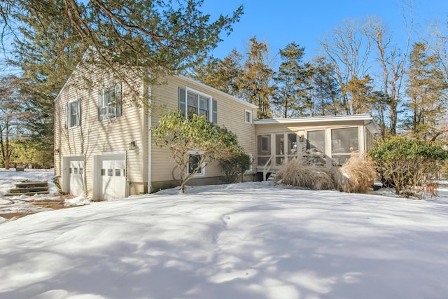 view of front of property with a garage and a sunroom