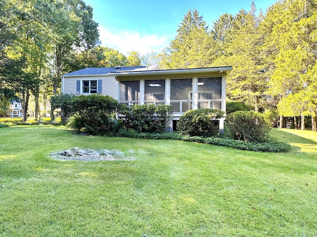 view of front of property with a sunroom and a front lawn