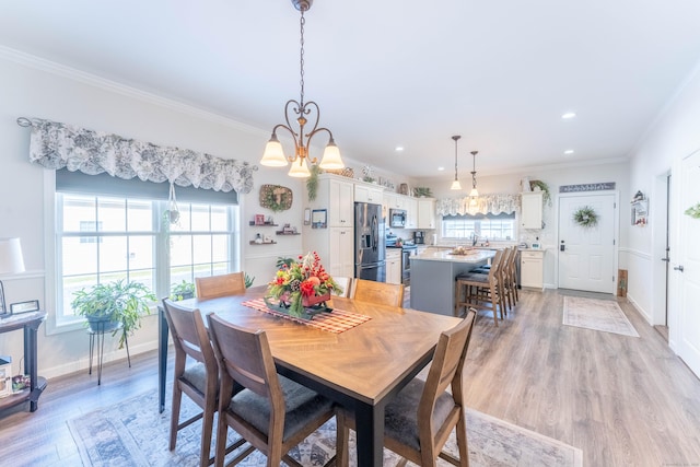 dining room with baseboards, light wood-style flooring, a wealth of natural light, and crown molding