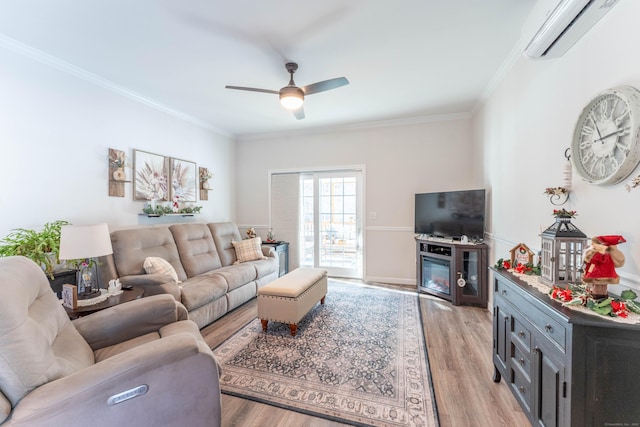 living area with ornamental molding, a wall unit AC, light wood-style flooring, and a ceiling fan