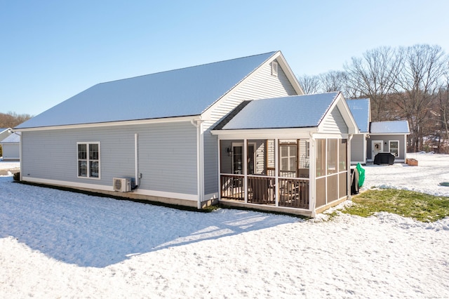 snow covered property with a sunroom