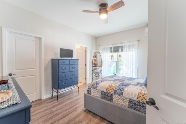 bedroom with ceiling fan, light wood-style flooring, and baseboards