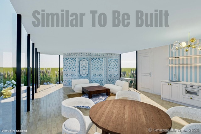 living area featuring a wall of windows, a notable chandelier, and light wood finished floors