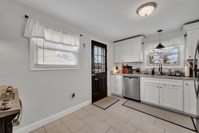 kitchen featuring dishwasher, a sink, a wealth of natural light, and light stone countertops