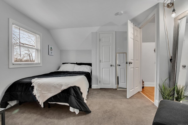 bedroom featuring lofted ceiling and light colored carpet