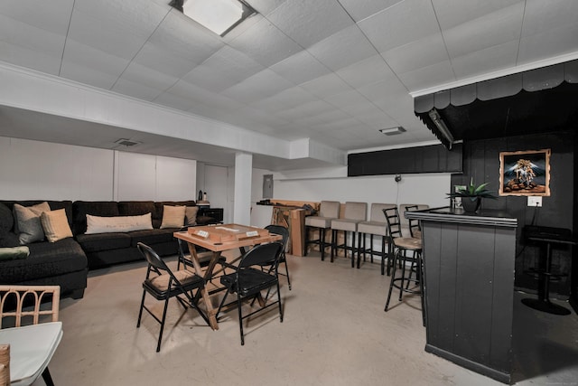 dining space featuring a bar, visible vents, and concrete flooring