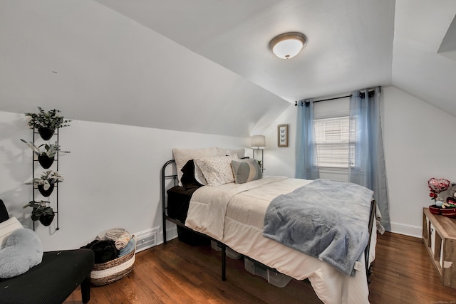 bedroom featuring lofted ceiling, dark wood-type flooring, visible vents, and baseboards