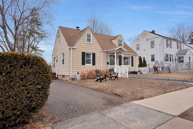 view of front of home featuring a shingled roof and fence