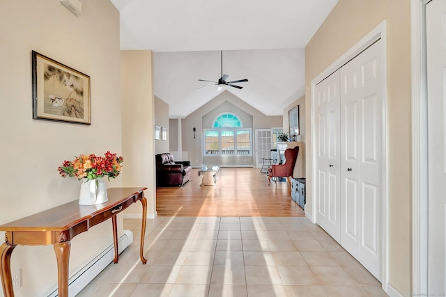 hallway with light tile patterned floors, baseboards, lofted ceiling, and baseboard heating