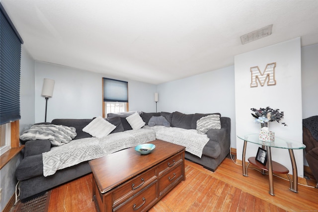 living room featuring light wood-style floors and visible vents