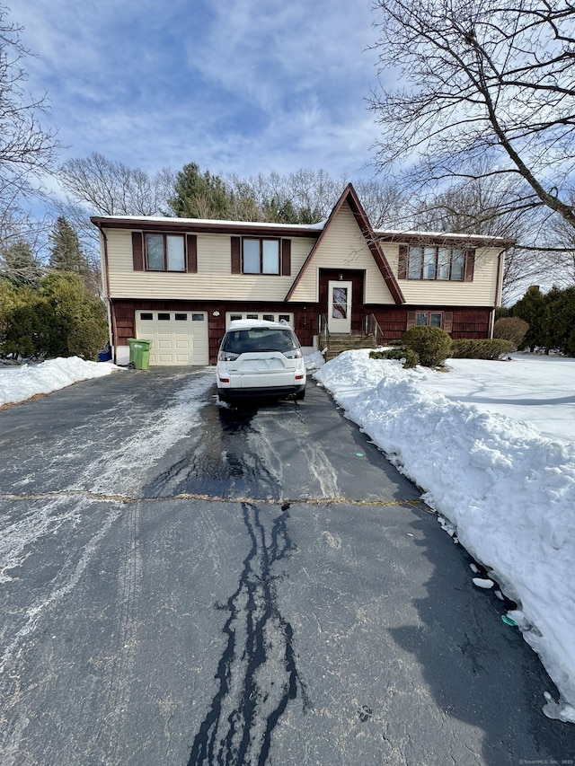 split foyer home with aphalt driveway and a garage