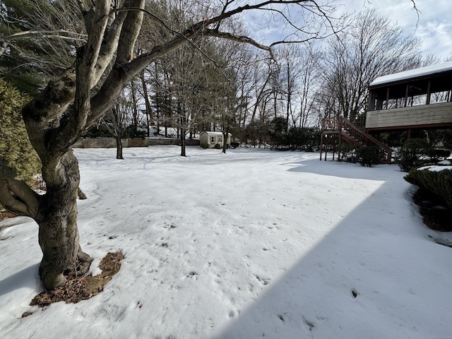 yard layered in snow with stairway and a sunroom