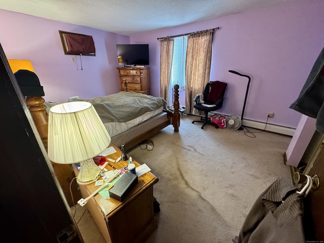 carpeted bedroom featuring a baseboard heating unit, a textured ceiling, and baseboards