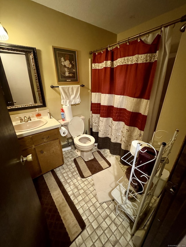 bathroom featuring curtained shower, vanity, and toilet