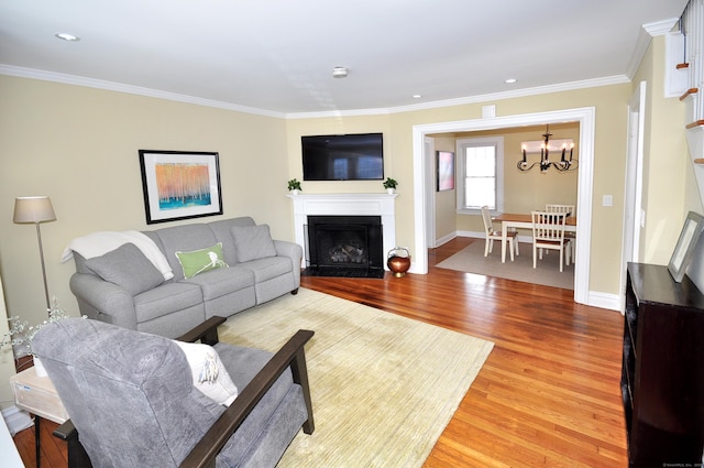 living room featuring baseboards, a fireplace, wood finished floors, and crown molding