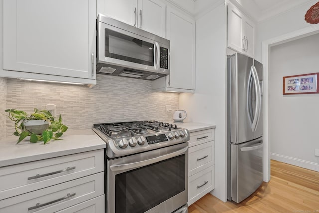 kitchen featuring appliances with stainless steel finishes, white cabinets, and light countertops