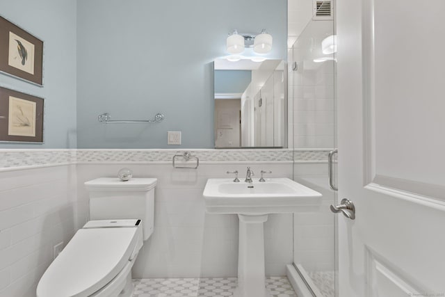 bathroom with wainscoting, visible vents, tile walls, and toilet