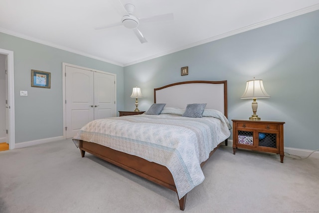 bedroom with light carpet, a closet, baseboards, and crown molding