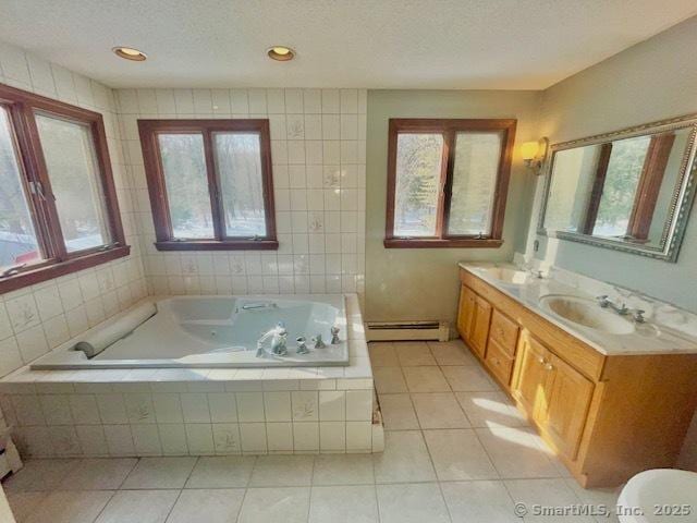 bathroom with a whirlpool tub, a baseboard radiator, a sink, and tile patterned floors