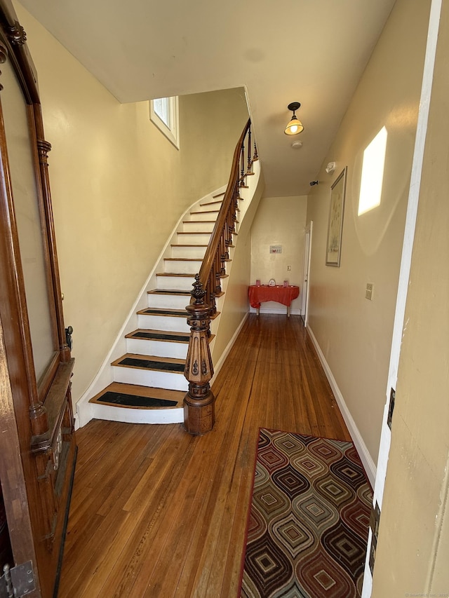 stairs with baseboards and wood finished floors